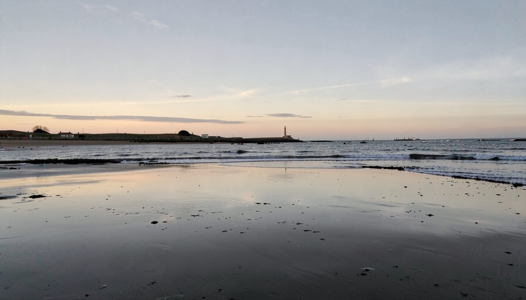 A reflective scene of Normandy beach at dusk in soft grey and pale gold tones, quiet and solemn